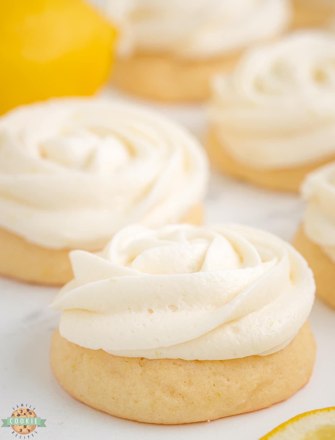 lemon frosting piped in a rosette on sugar cookies
