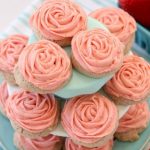 Frosted Strawberry Cookies made by adding fresh strawberries to a simple sugar cookie dough. No rolling out or chilling necessary! Just bake and top with my amazing strawberry buttercream frosting. Easy Strawberry Cookies piped with a super simple pink rose, so they taste incredible and they’re pretty too!