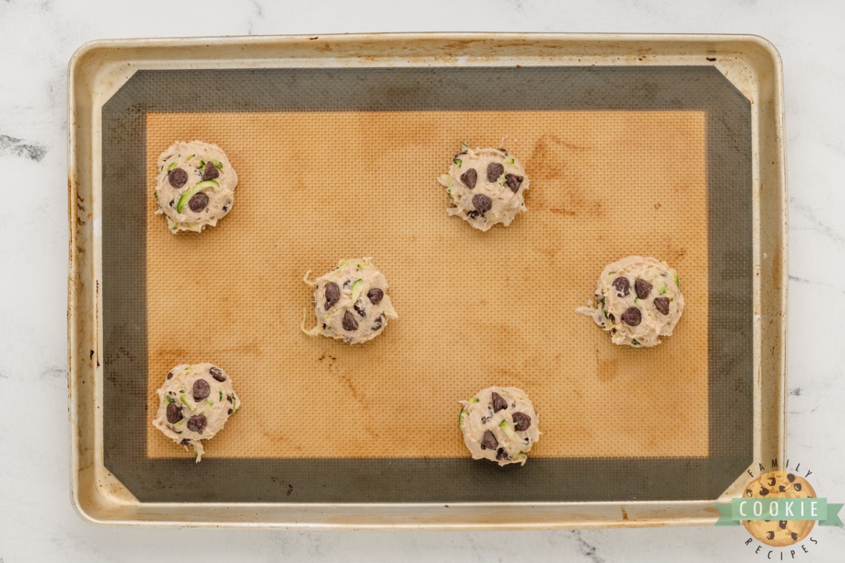 Scoops of cookie dough on cookie sheet. 