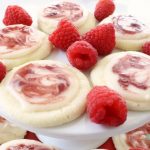 Raspberry Meltaway Cookies just melt in your mouth! Soft dough made with cornstarch and powdered sugar compliments these raspberry cookies beautifully. Perfect topped with a simple almond glaze swirled with raspberry jam.