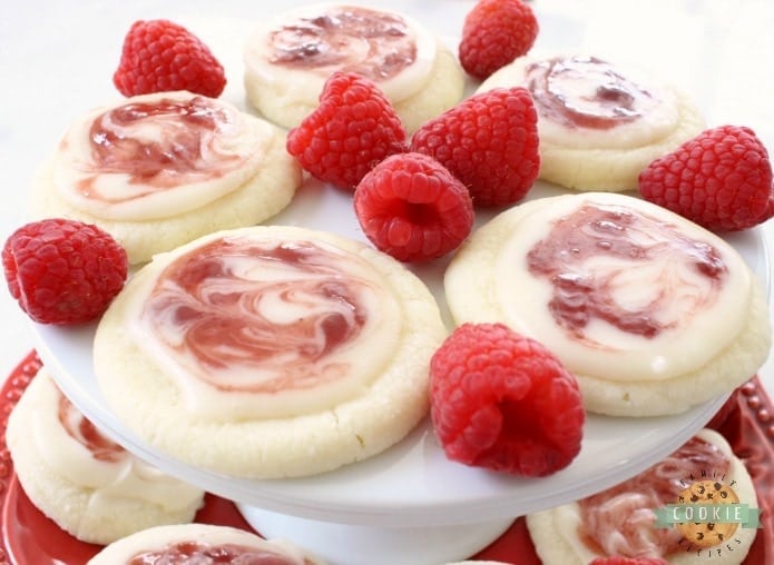 Raspberry Meltaway Cookies just melt in your mouth! Soft dough made with cornstarch and powdered sugar compliments these raspberry cookies beautifully. Perfect topped with a simple almond glaze swirled with raspberry jam.