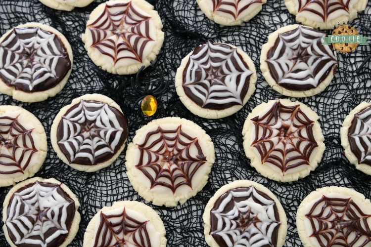 Halloween Cobweb Cookies are spectacularly spooky and completely delicious! Sugar cookies topped with chocolate & vanilla icing- no coloring! Quick & easy spider web design made in seconds. Perfect Halloween treats!
