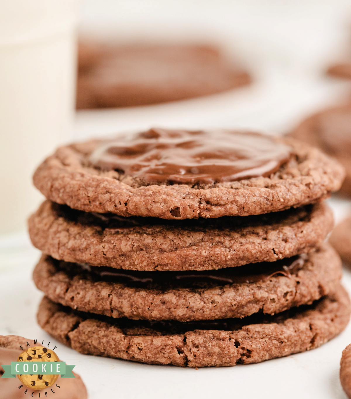 Stack of brownie mix cookies that are frosted with a melted Hershey bar.