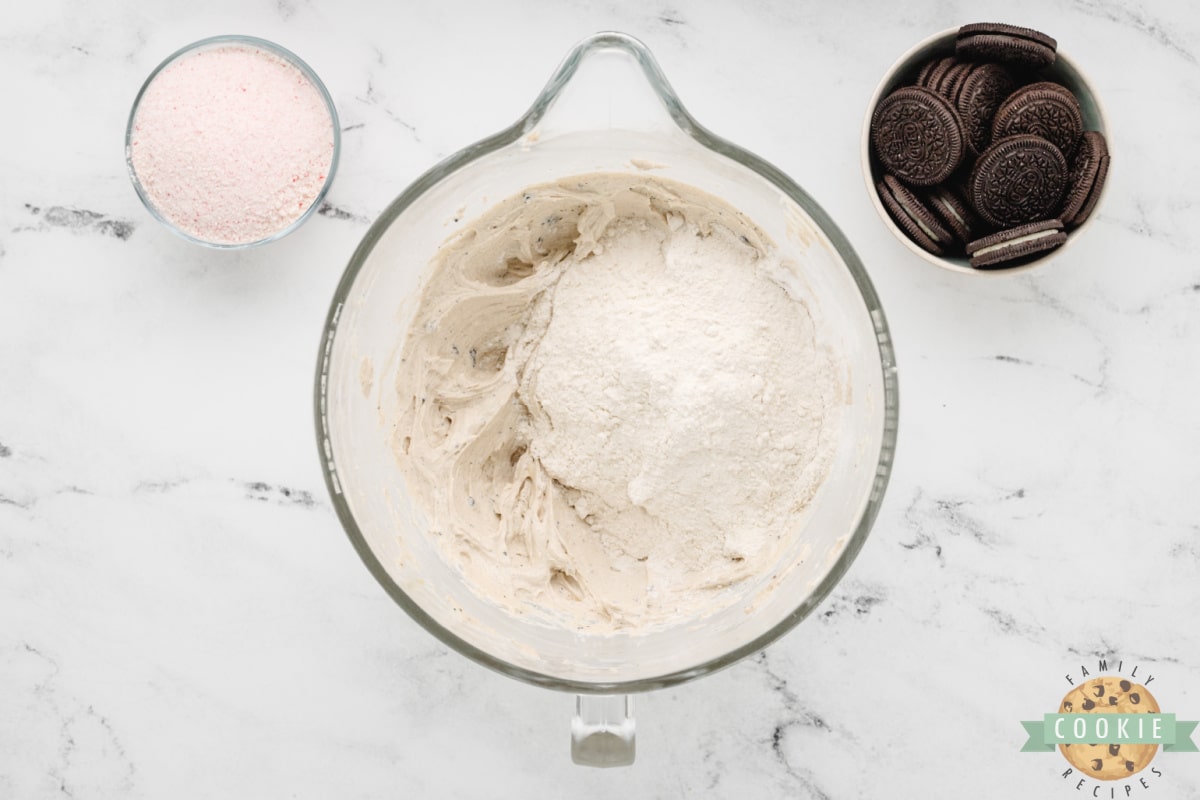 Adding dry ingredients to cookie dough. 