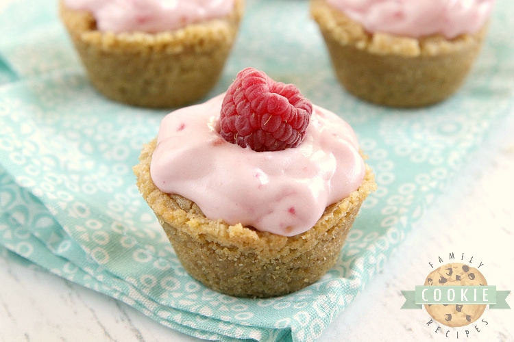 Raspberry Cheesecake Cookie Cups have a raspberry cheesecake filling in a bite-sized graham cracker cookie crust. These delicious cookie cups taste just like raspberry cheesecake and only take a few minutes to make!