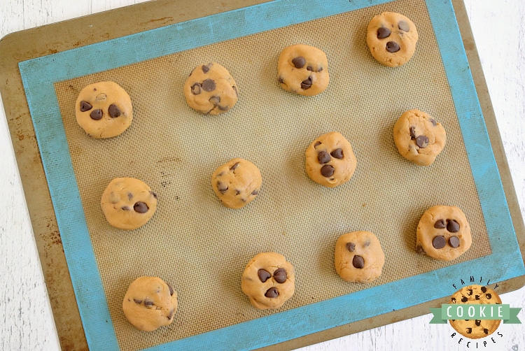 Scooping out butterscotch chocolate chip cookie dough into cookies