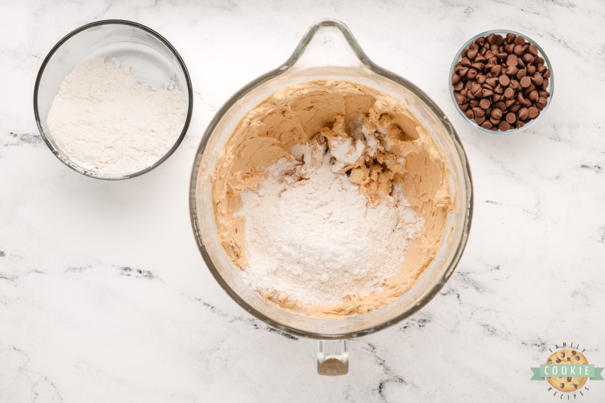 Add flour and baking soda to cookie dough. 