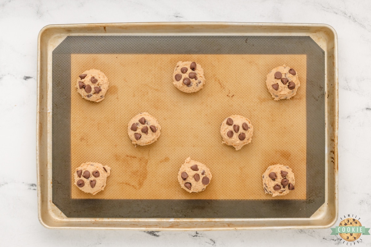 Scoops of cookie dough on a cookie sheet. 