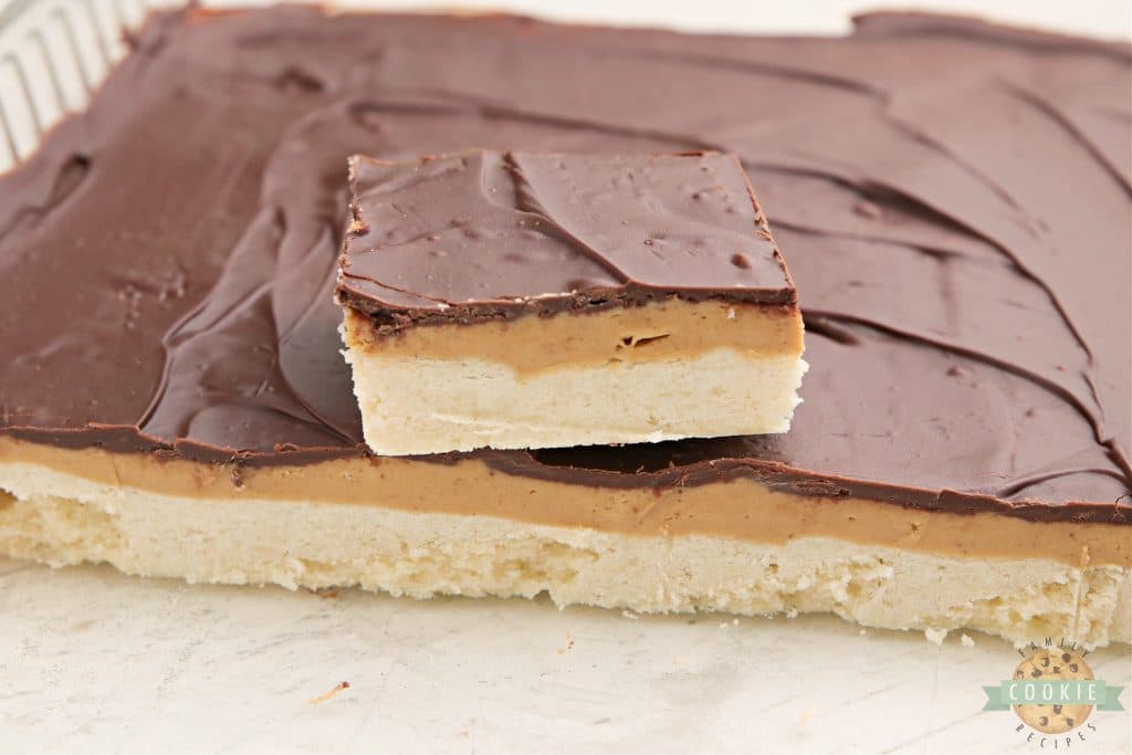 Cookie bars with a shortbread crust, a peanut layer and chocolate on top