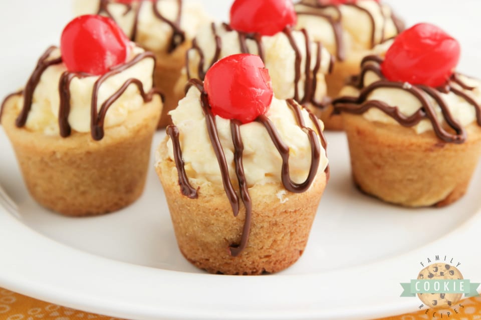 Banana Split Cookie Cups taste like your favorite banana split dessert in cookie form! Banana flavored cookies filled with pineapple cream and topped with chocolate and a cherry! 