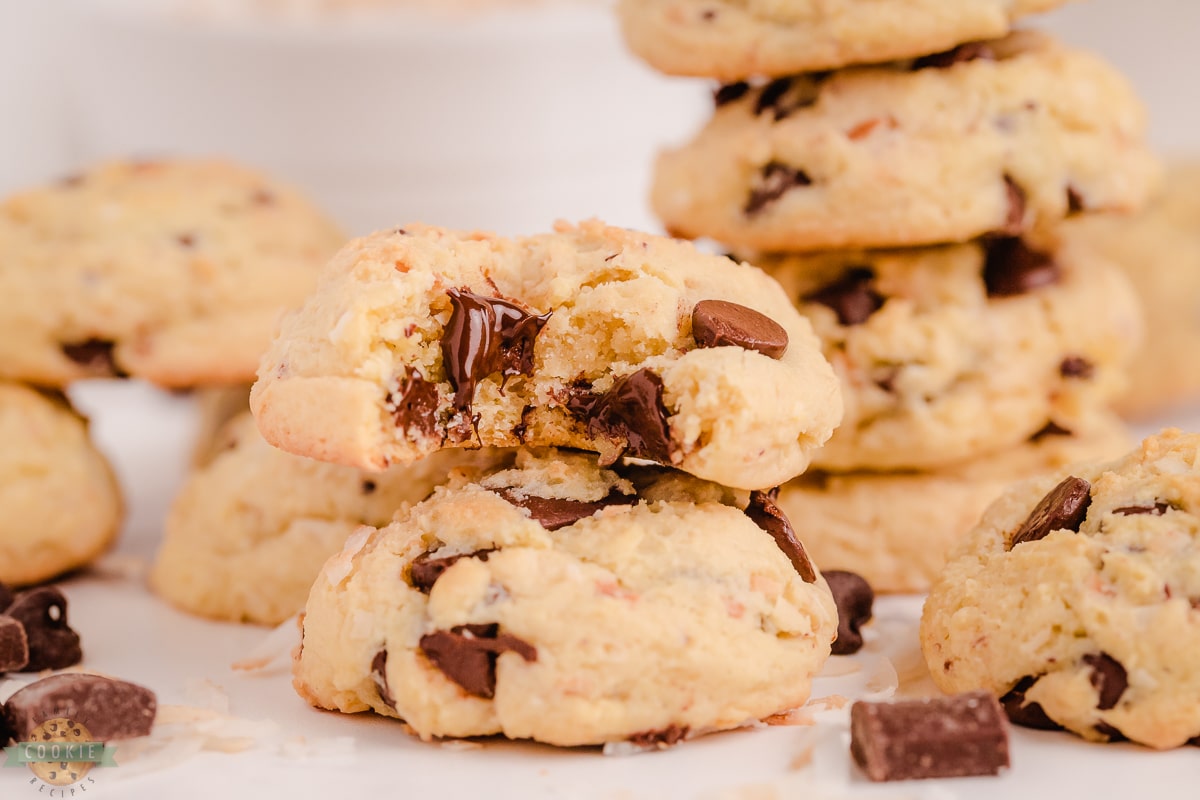 stacked coconut chocolate chip cookies with a bite taken out of one