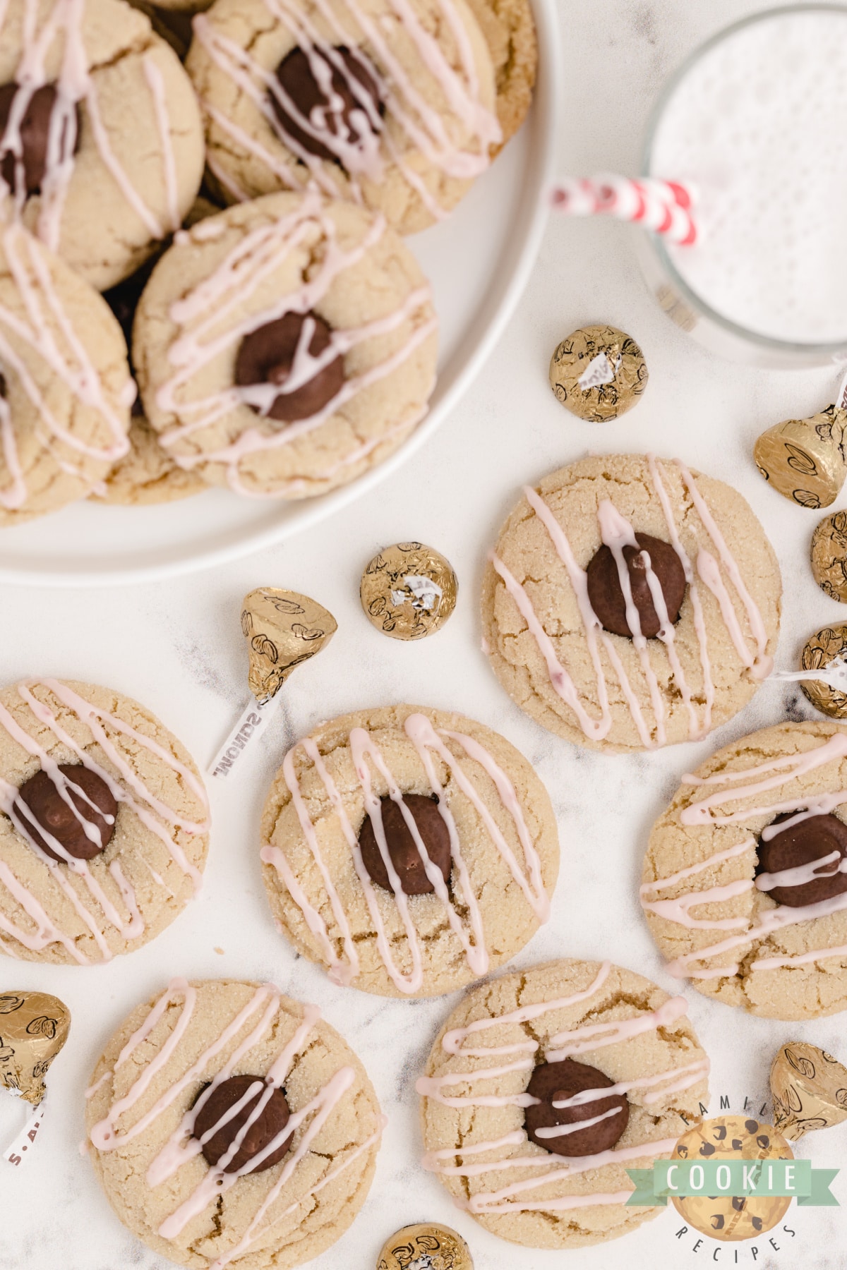 Almond Kiss Cookies made with almond extract and Hershey kisses with almonds! Drizzled with a simple raspberry glaze, these make a fantastic alternative to the traditional peanut butter blossoms!