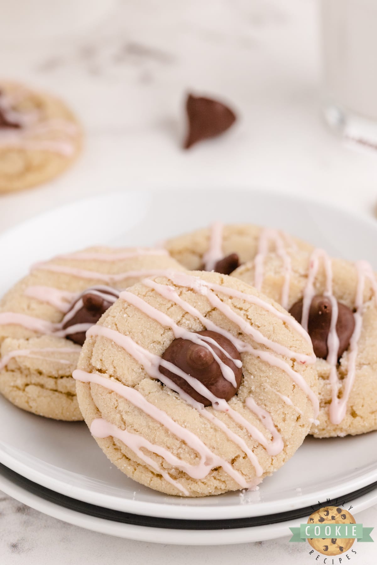 Almond Kiss Cookies made with almond extract and Hershey kisses with almonds! Drizzled with a simple raspberry glaze, these make a fantastic alternative to the traditional peanut butter blossoms!