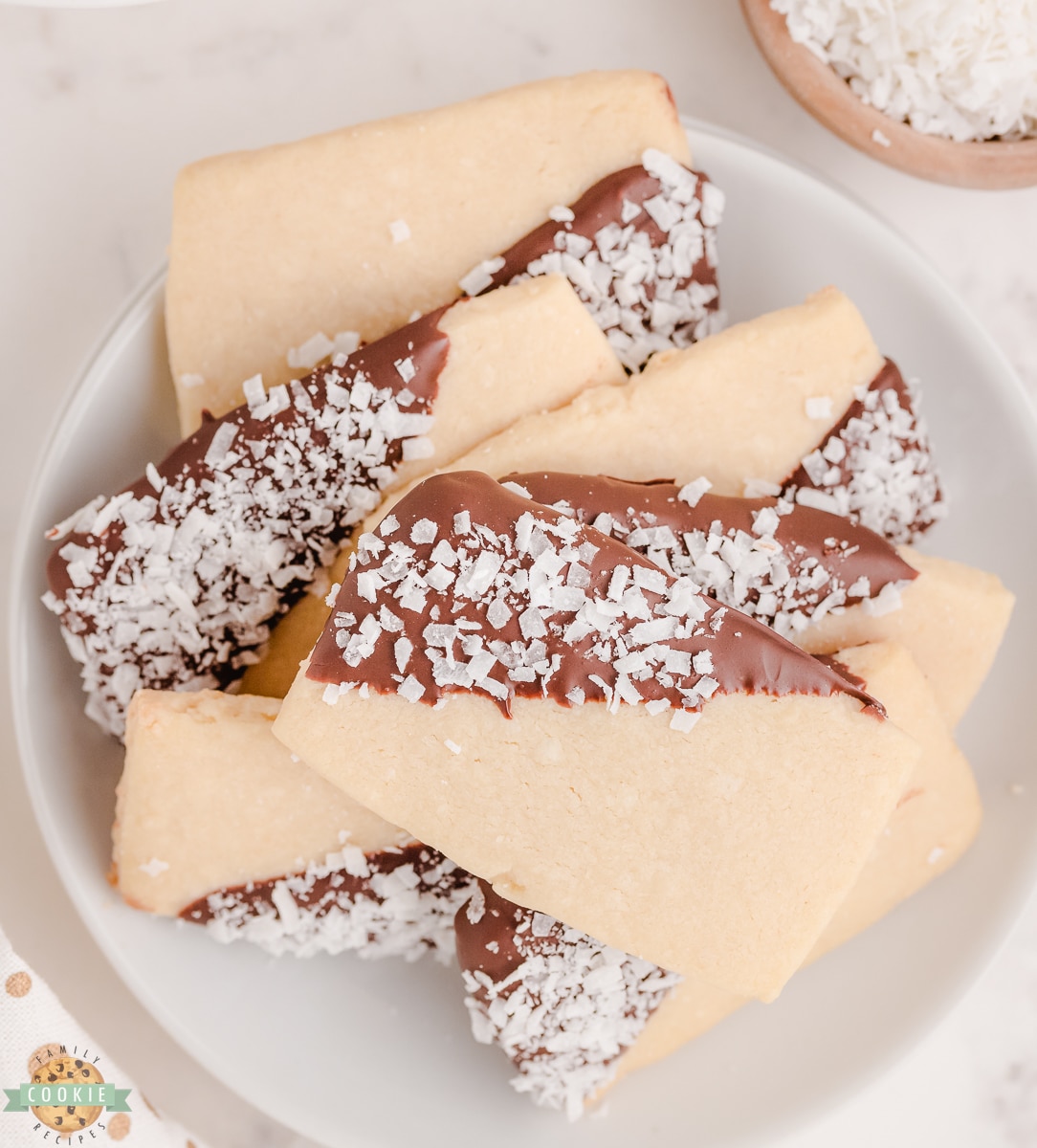 chocolate dipped coconut shortbread cookies in a stack