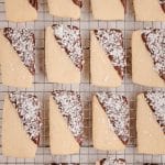 chocolate dipped coconut shortbread cookies on a cooling rack