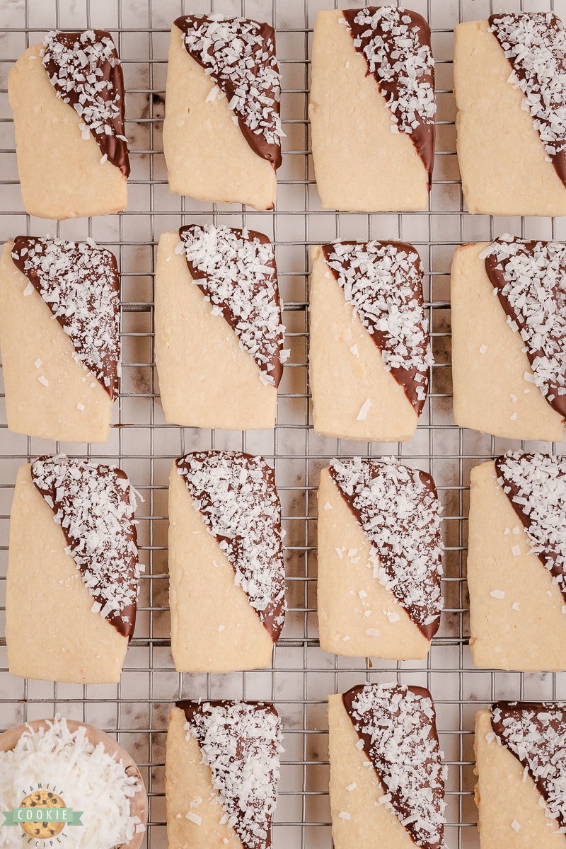 chocolate dipped coconut shortbread cookies on a cooling rack