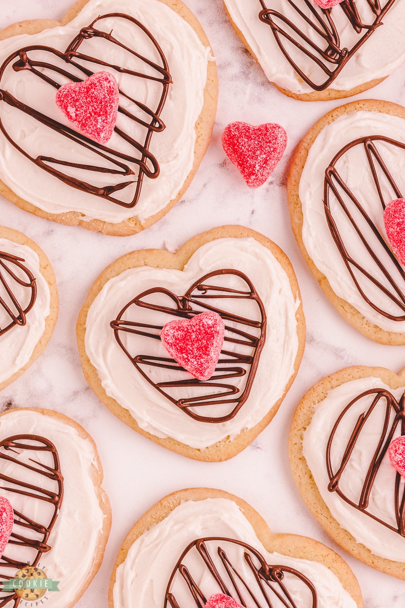 heart sugar cookies with icing, a chocolate heart and a candy heart
