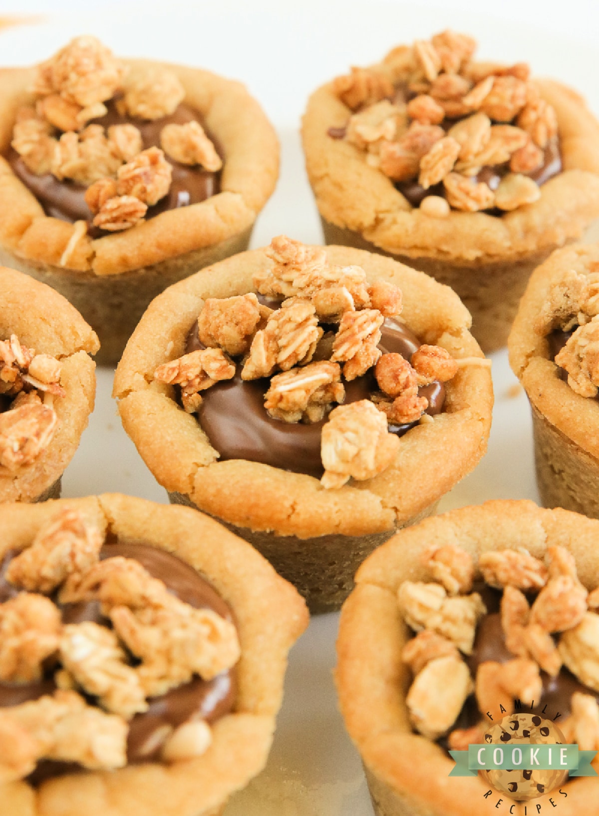 Cups easily made with only 5 ingredients! Peanut butter cookie cups filled with creamy peanut butter and chocolate layers and topped with granola for a little bit of a crunch! 