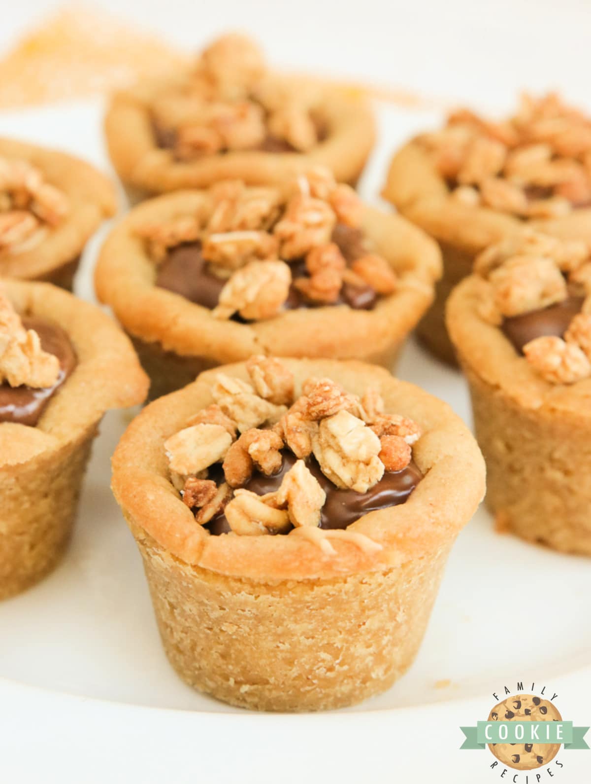 Cups easily made with only 5 ingredients! Peanut butter cookie cups filled with creamy peanut butter and chocolate layers and topped with granola for a little bit of a crunch! 