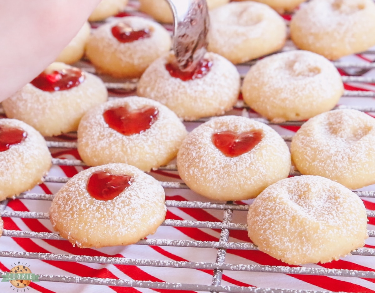 filling the heart with jam in thumbprint cookies