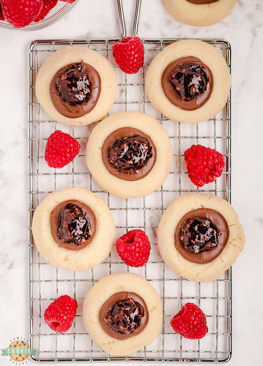 raspberry thumbprint cookies on a cooling rack