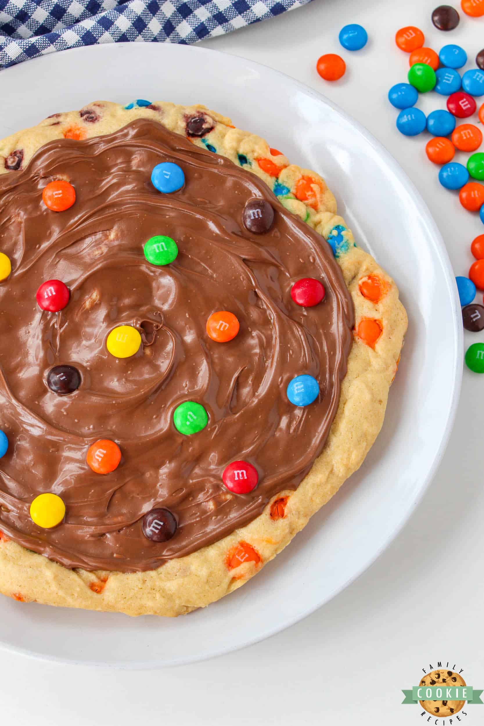 Dessert pizza frosted with milk chocolate and topped with M&Ms