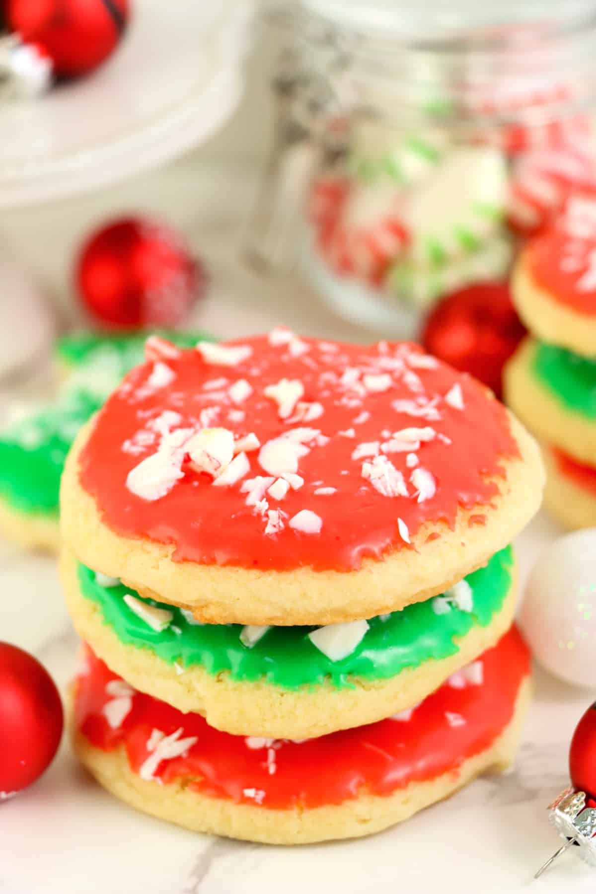 Christmas Sugar Cookies are soft and light sugar cookies dipped in vibrant frosting and topped with crushed mints. Easy holiday sugar cookie recipe that is perfect for parties and goody platters. No chilling, rolling out the dough or cutting out any cookies!