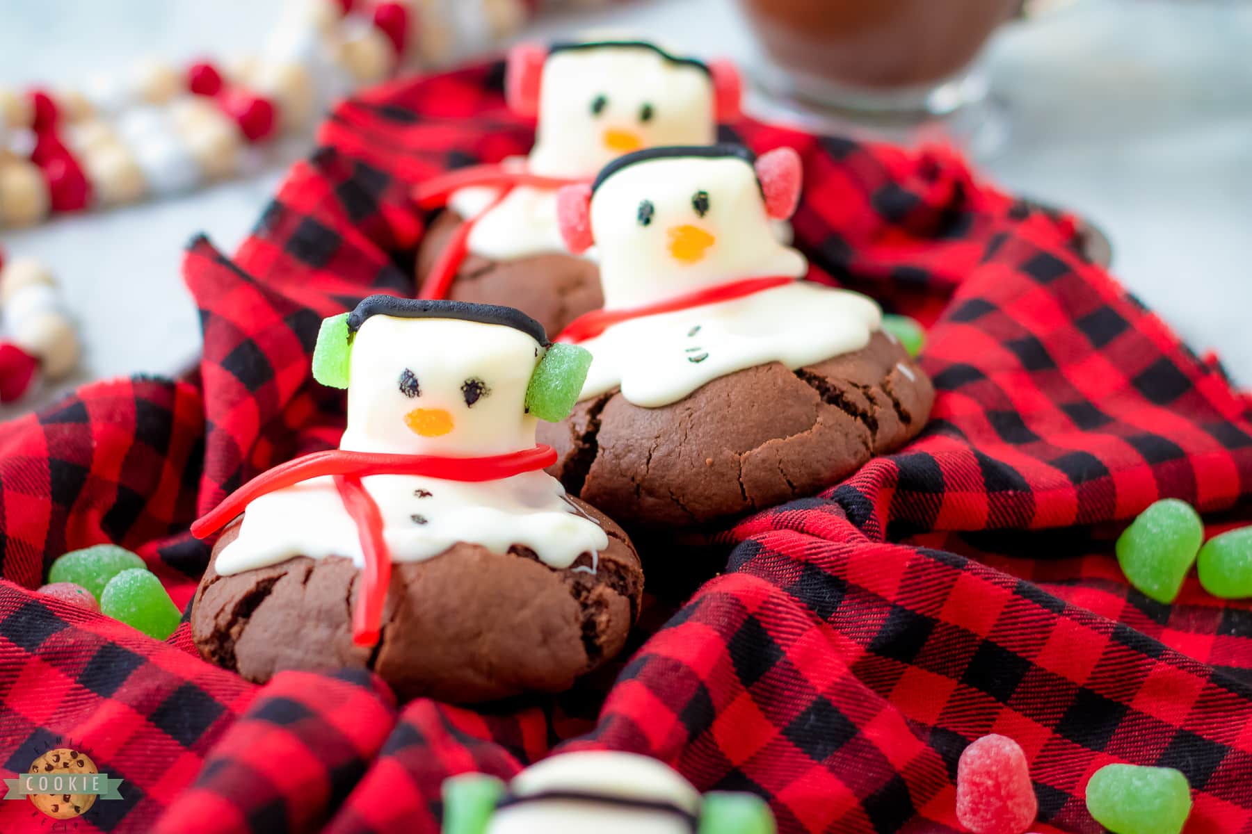 bakery style snowman cookies on a red checked cloth