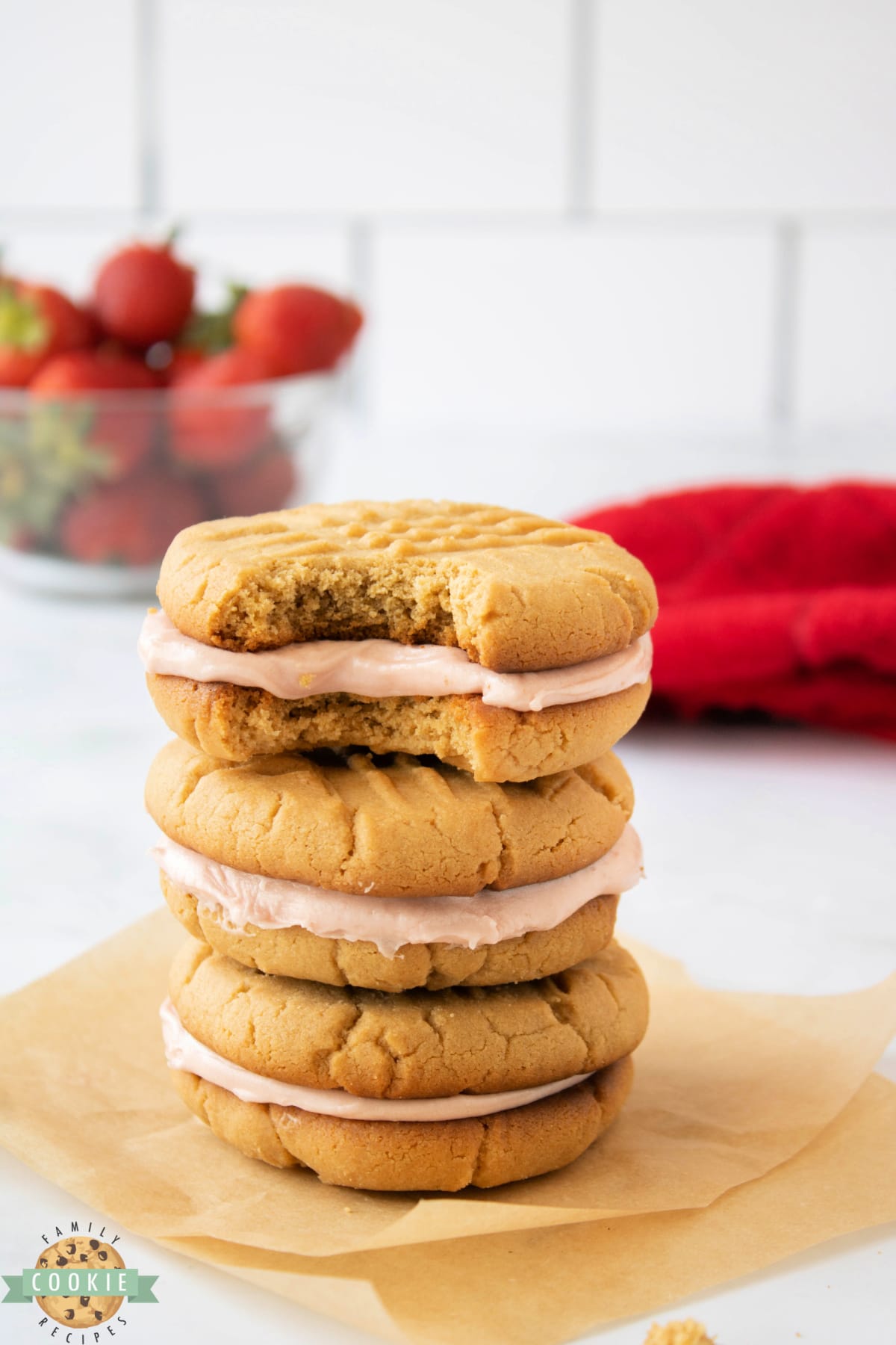 Peanut Butter and Jelly Sandwich Cookies are made by spreading a creamy strawberry buttercream frosting between two soft and chewy peanut butter cookies.  Your favorite childhood sandwich in the form of a dessert that everyone loves! 