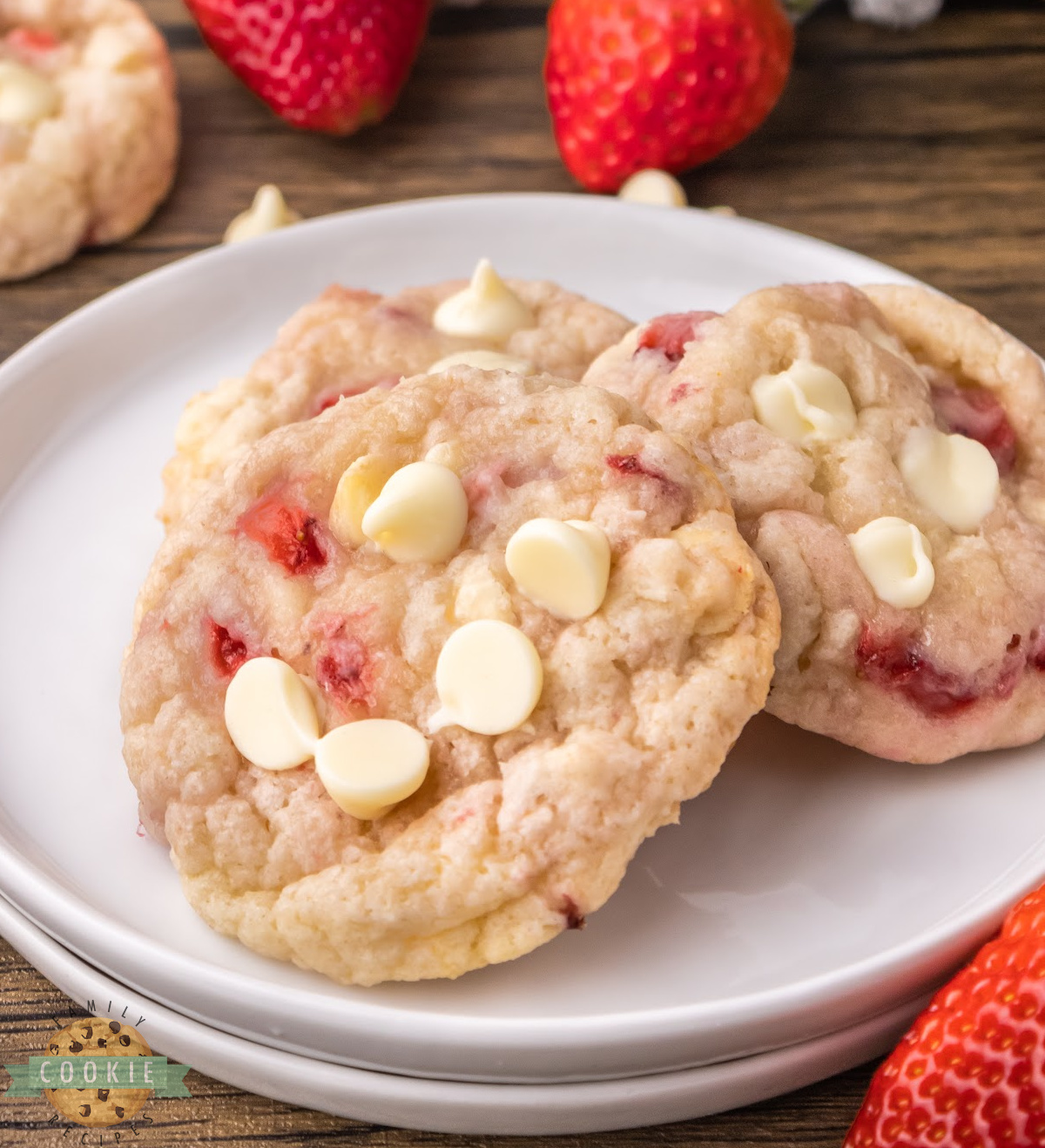 Strawberry cookies with white chocolate chips on a white plate.