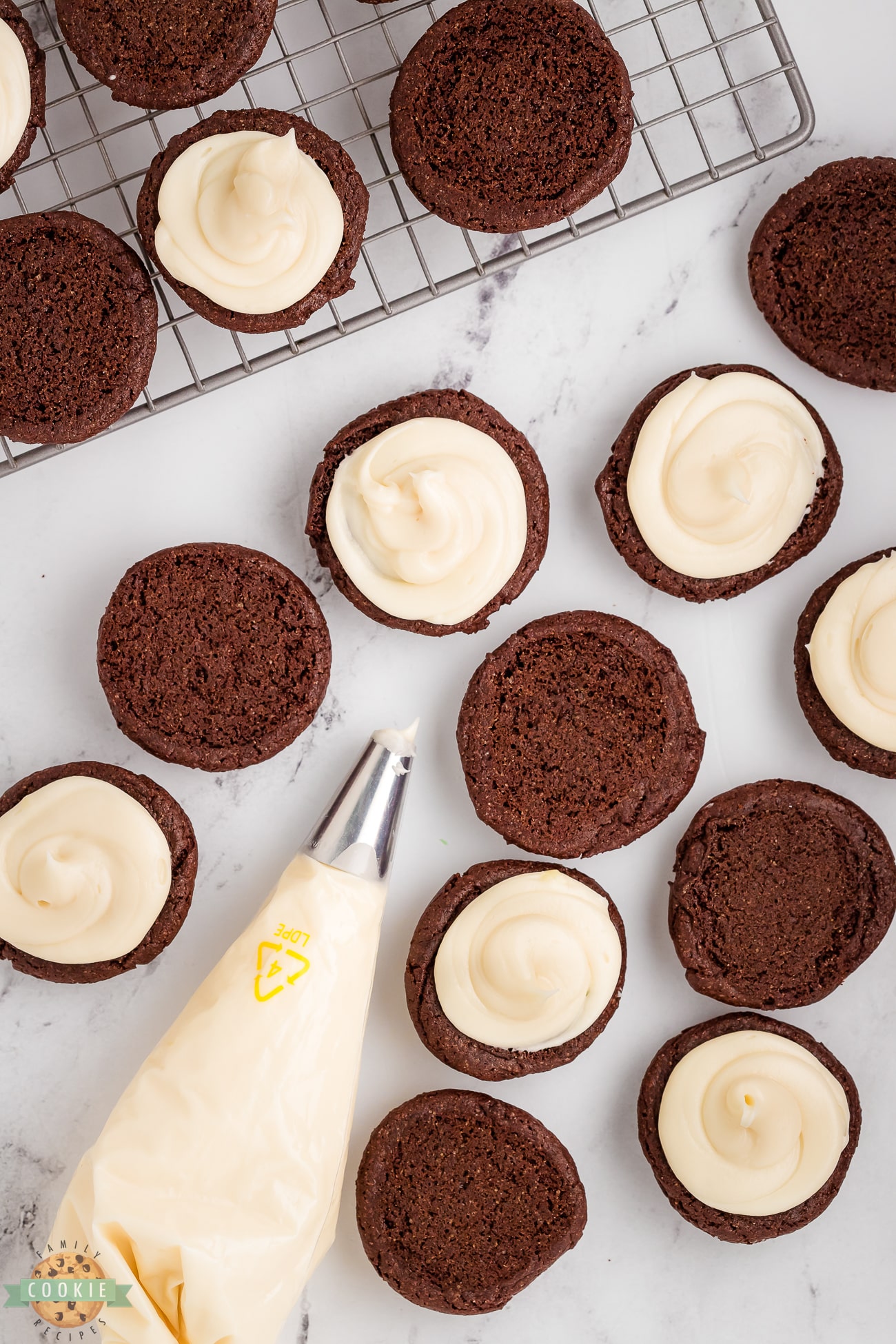 adding cream cheese frosting to homemade oreos