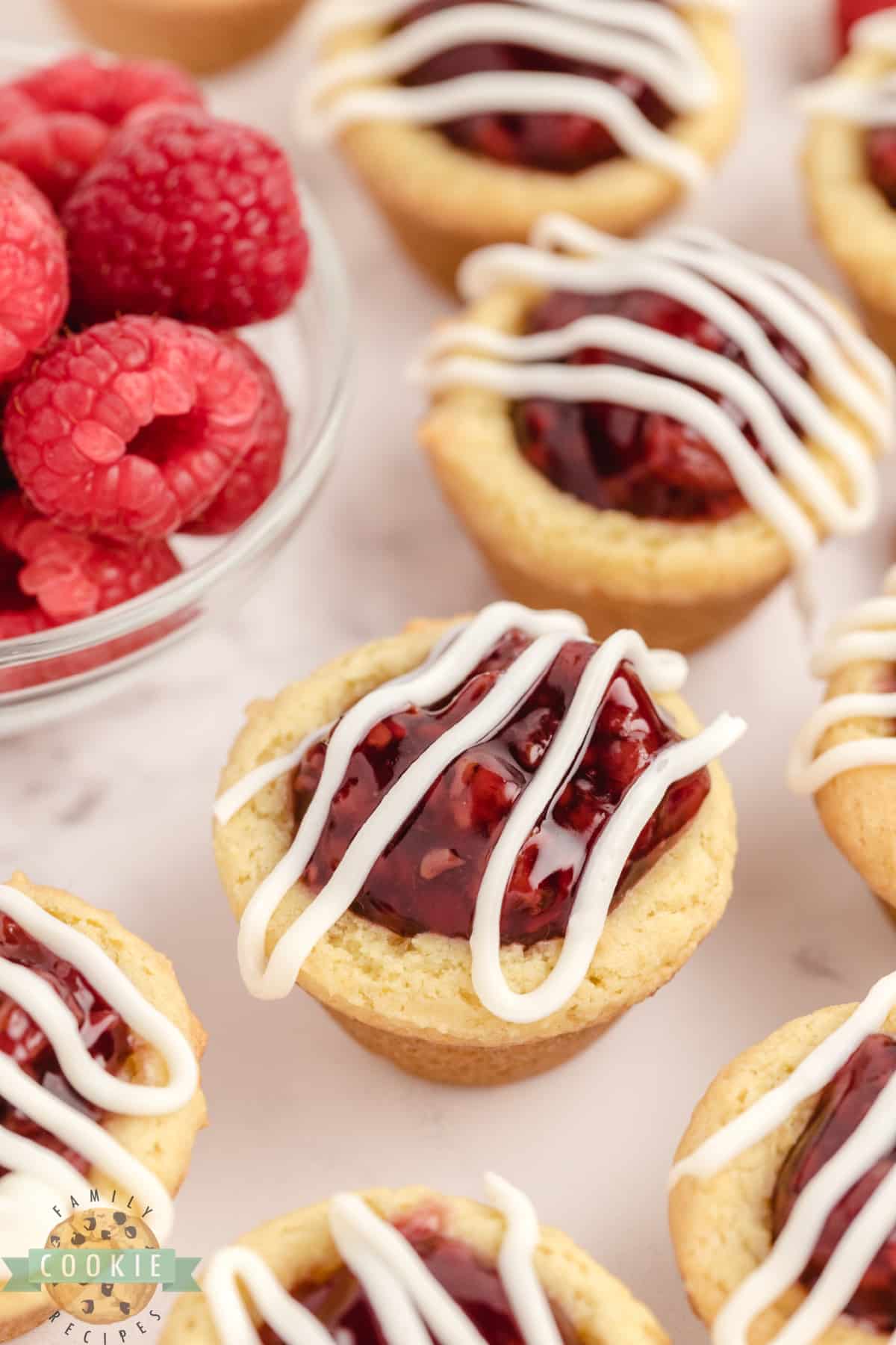 Lemon cookie cup with raspberry pie filling and white chocolate drizzle