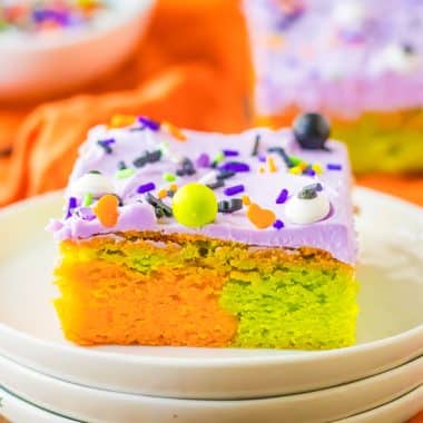marbled orange and green Halloween sugar cookie bars with purple frosting on a plate