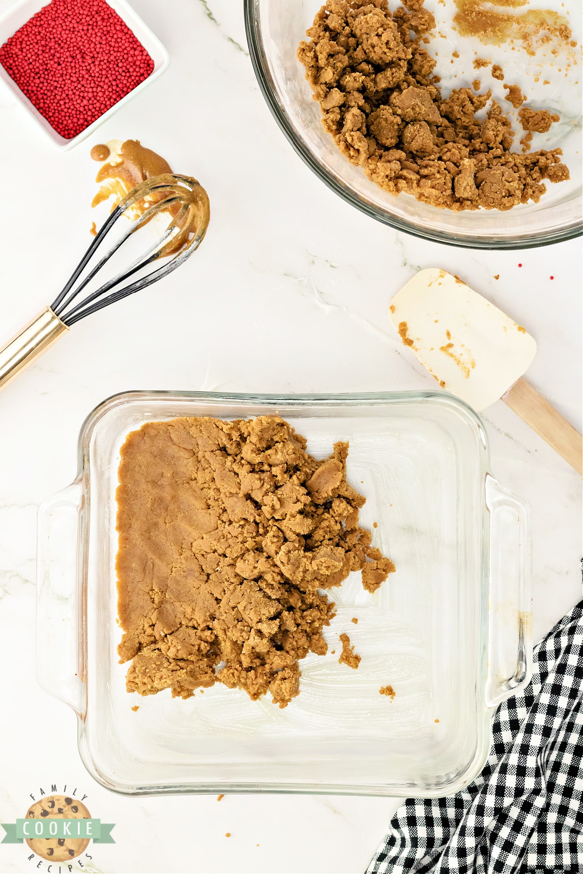 Pressing gingerbread cookie dough into the pan. 