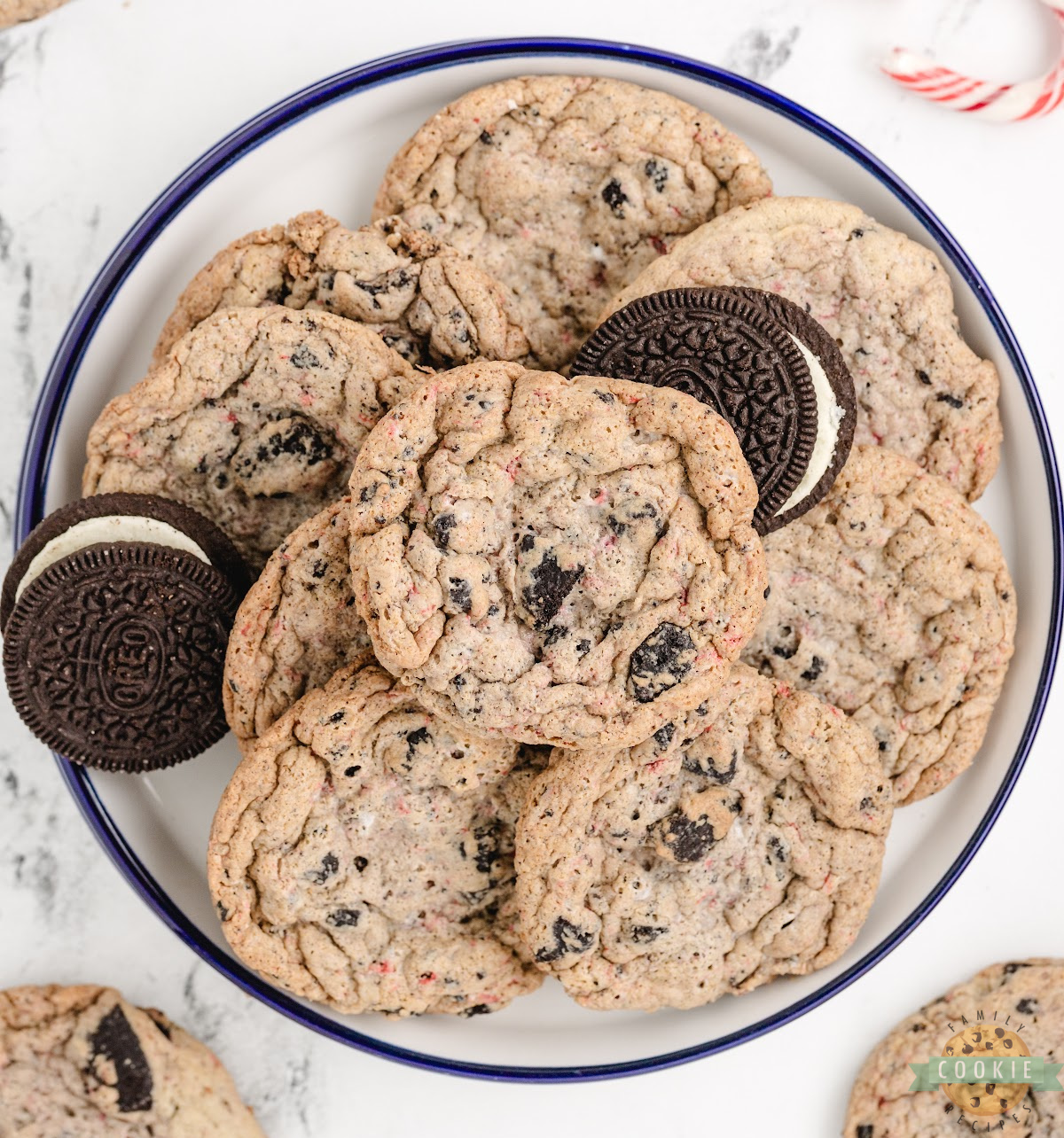 Soft peppermint Oreo cookies on a holiday plate with crushed candy canes scattered around.