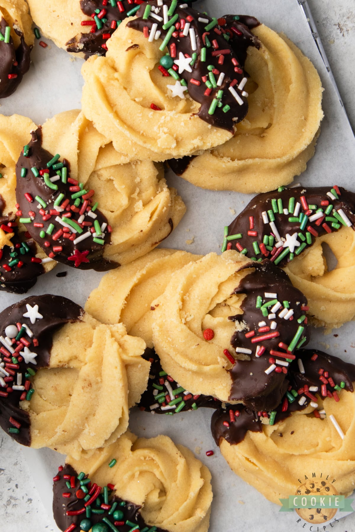 Classic holiday butter cookies made with buttery cookie dough and covered in chocolate & sprinkles. Incredible shortbread cookie with a delicate texture and fantastic flavor!