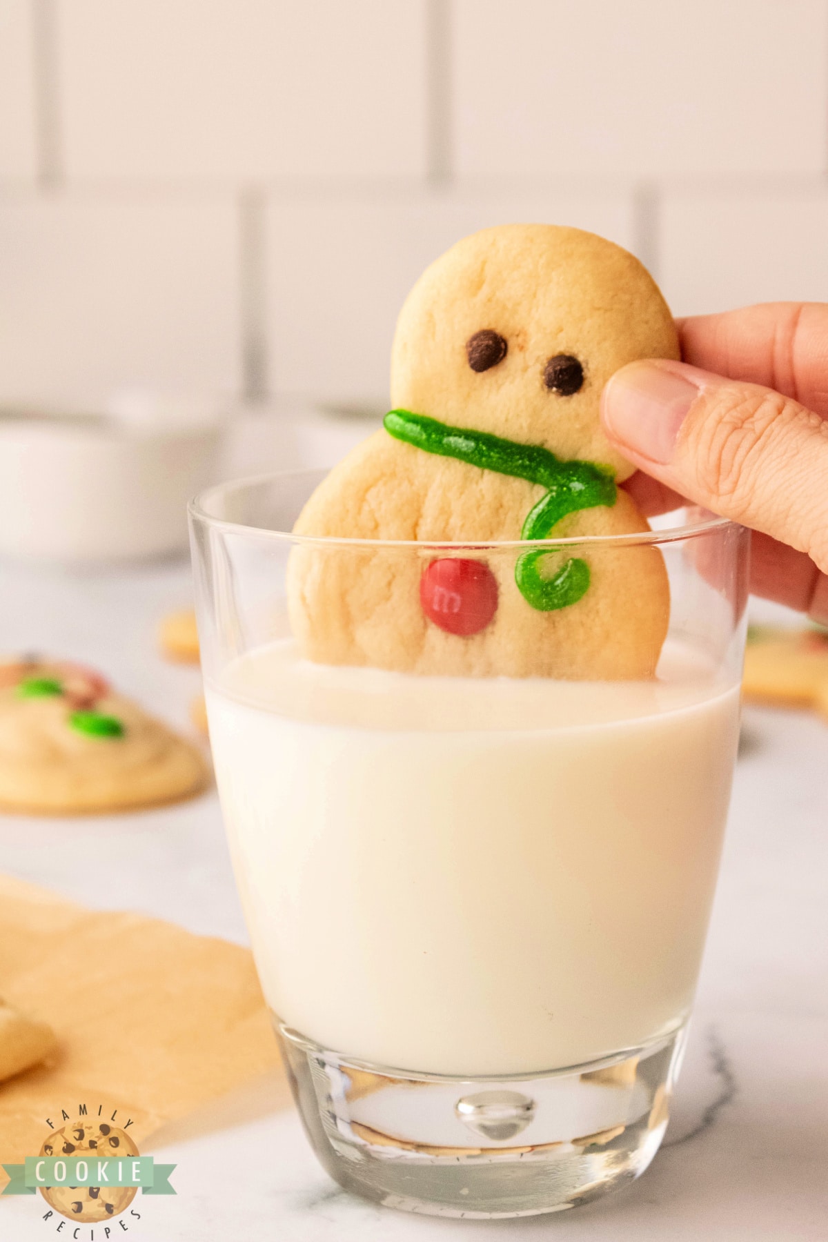 Dipping sugar cookie in a glass of milk.