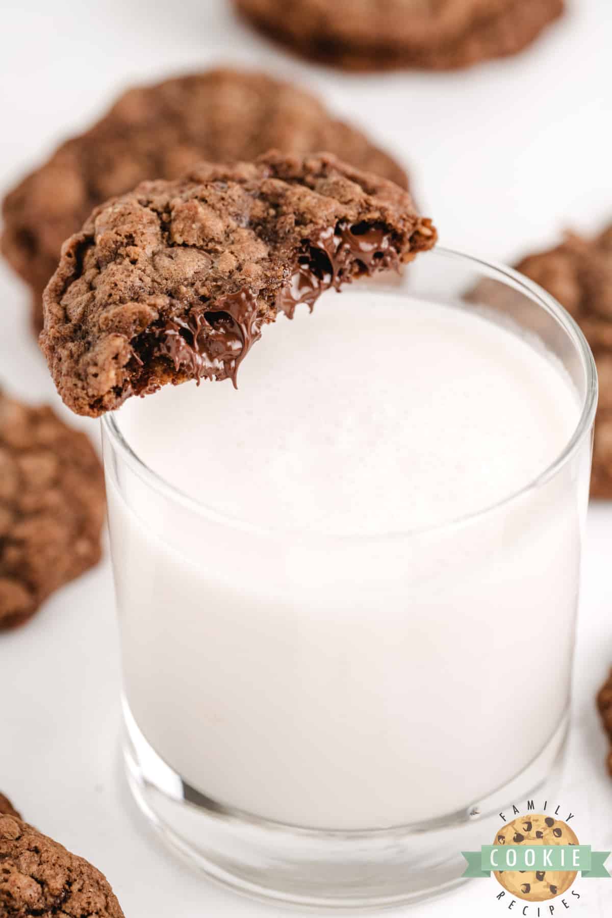 Dipping chocolate oatmeal cookie with chocolate chips in a glass of milk. 