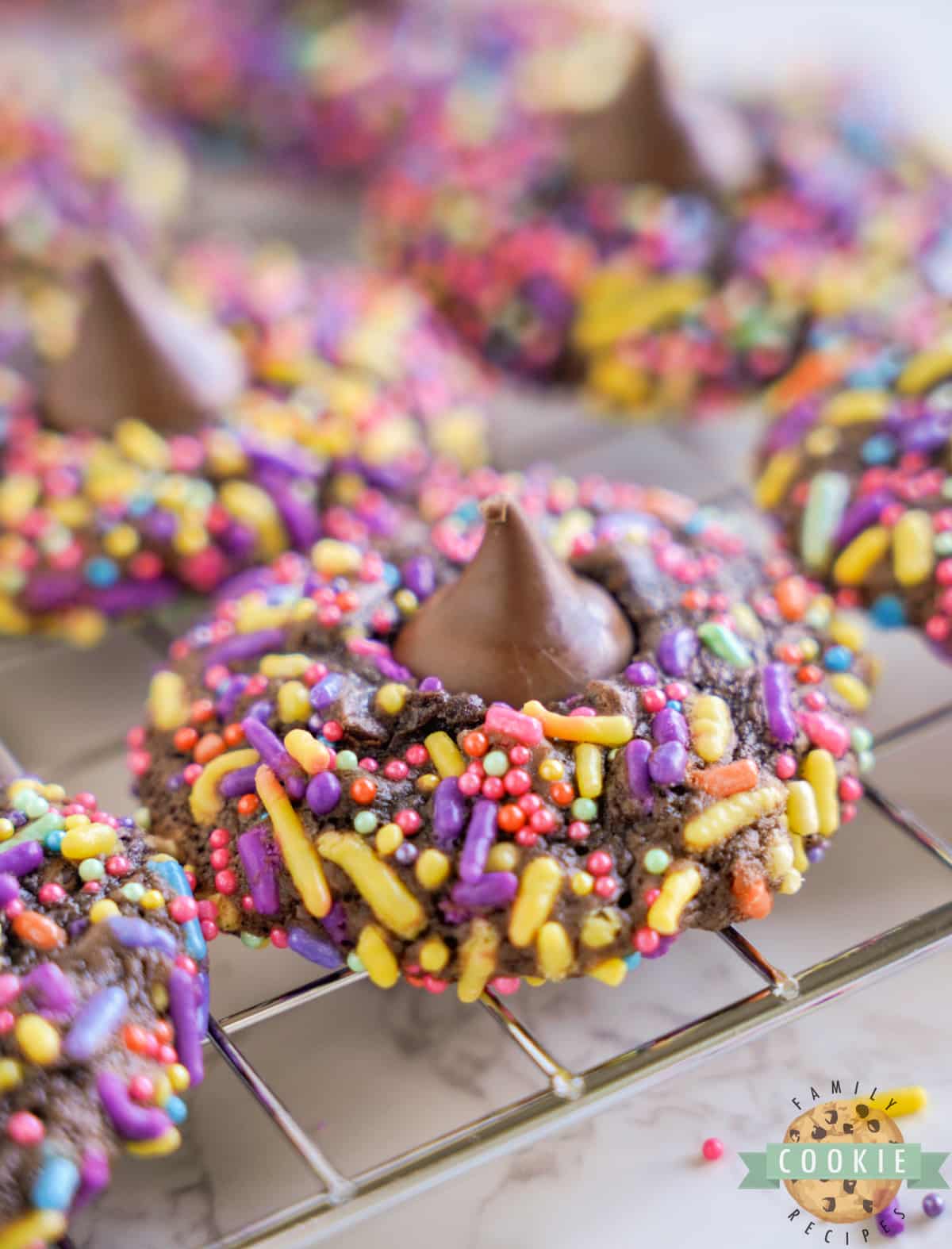 Easter Brownie Blossom Cookies are rolled in sprinkles before being baked and topped with a Hershey's Kiss. This simple brownie mix cookie recipe is perfect for spring! 