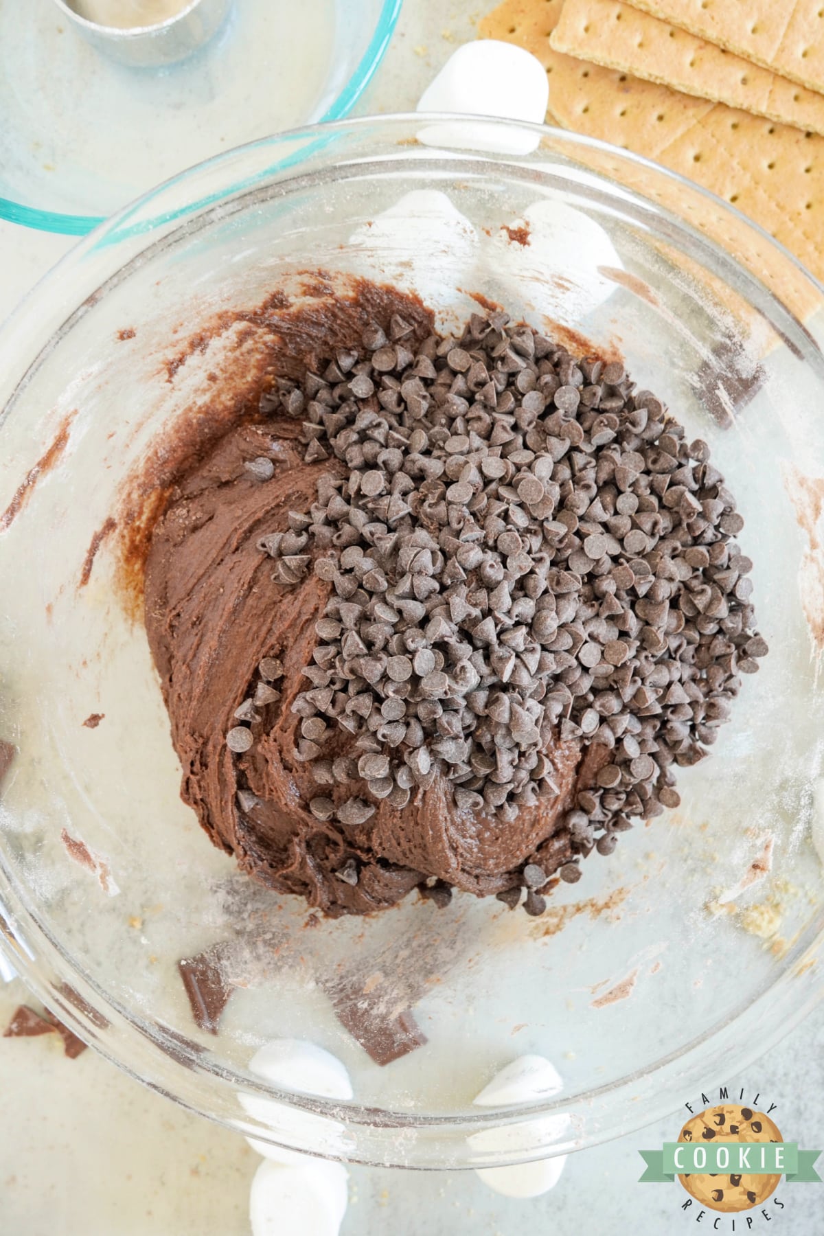 Add chocolate chips to brownie cookie dough. 