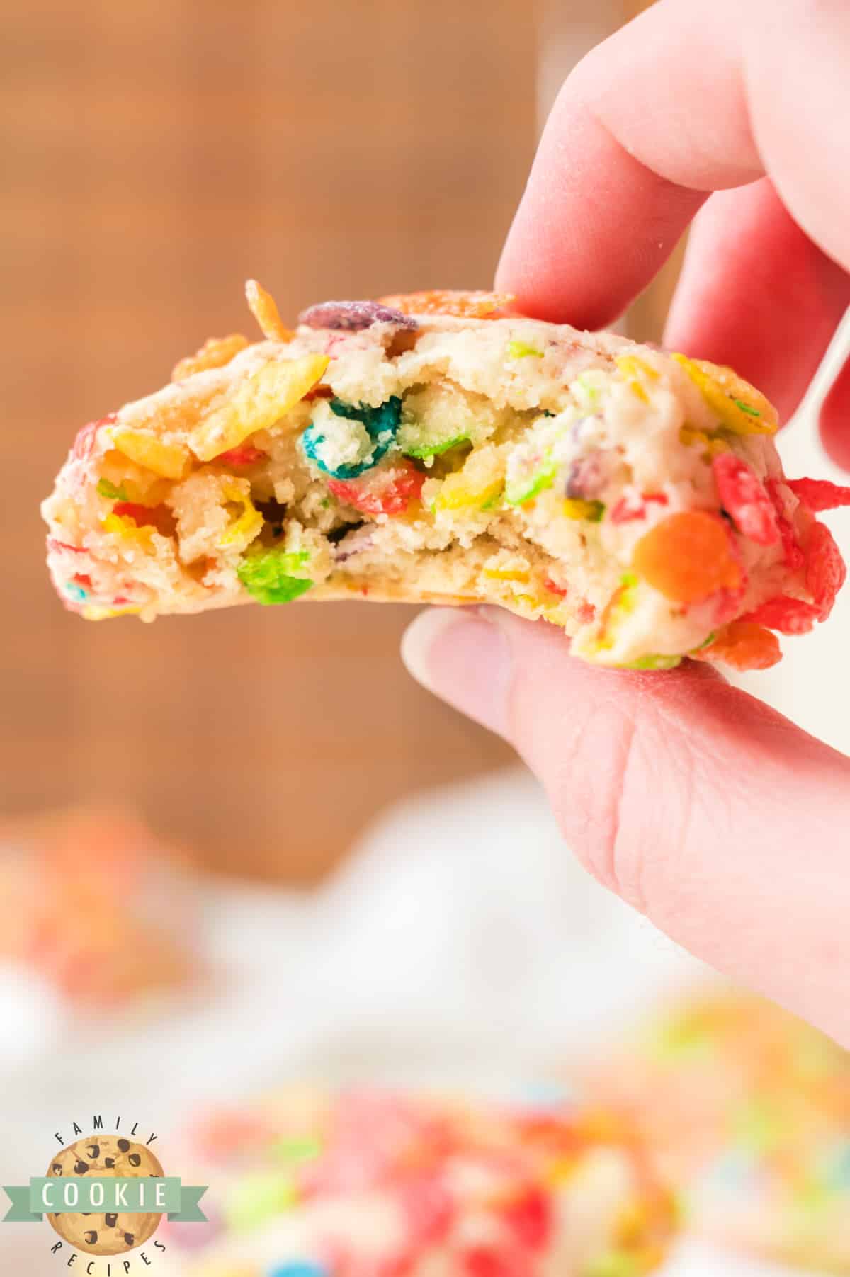 Bite of cookie with fruity pebbles cereal.