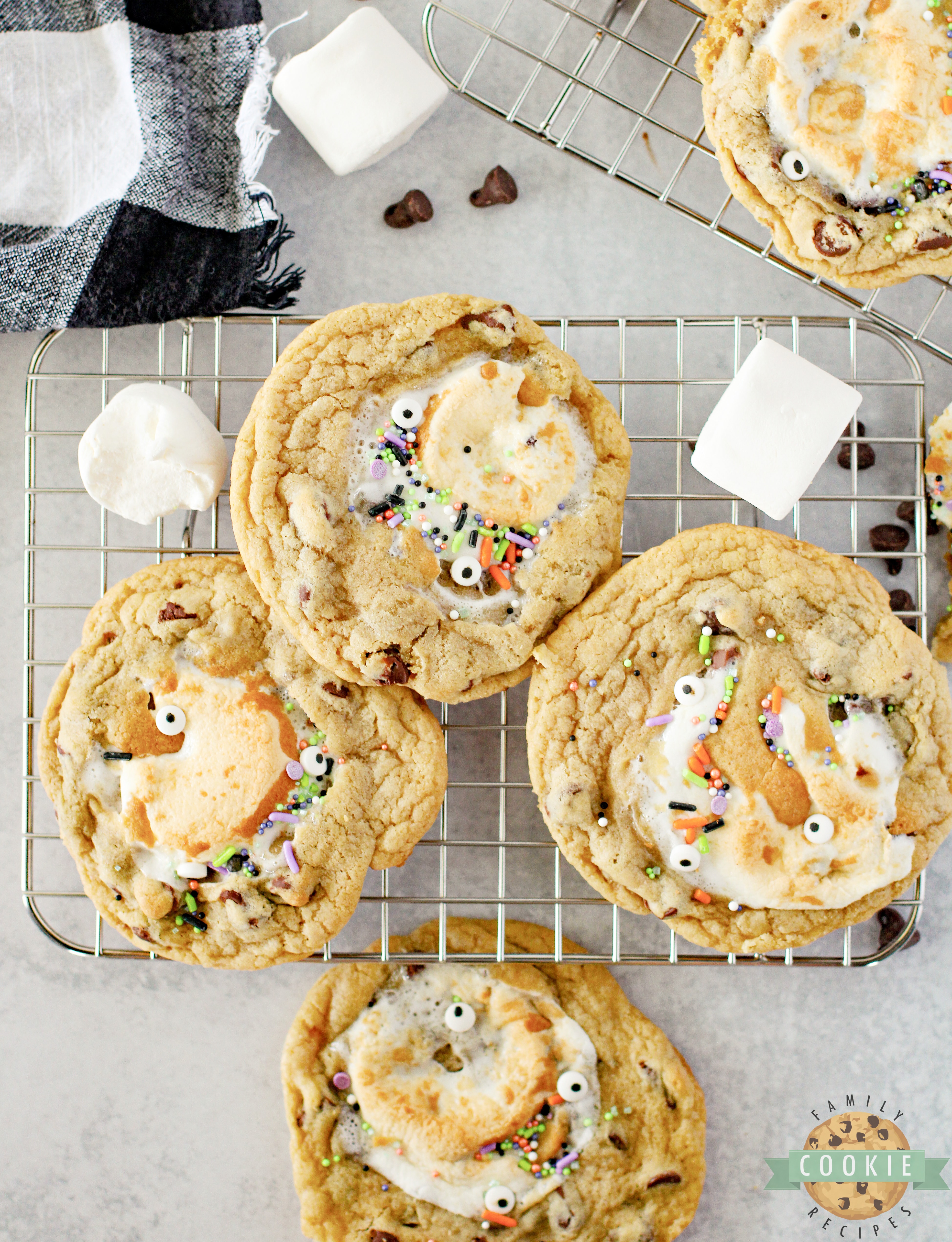 Monster Stuffed S'mores Cookies are chocolate chip cookies stuffed with Hershey bars and marshmallows. Add some monster eyes and festive sprinkles to make perfect Halloween cookies!