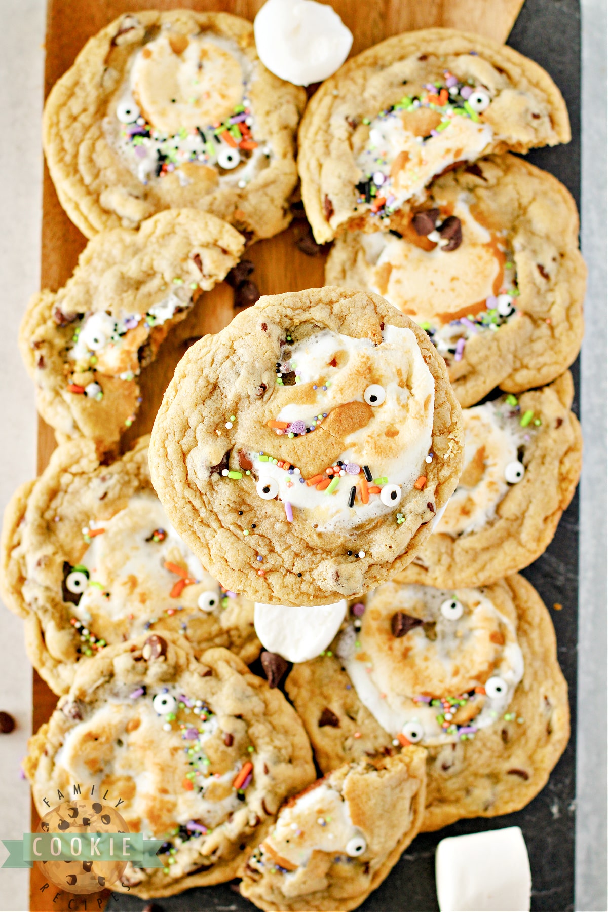 Monster Stuffed S'mores Cookies are chocolate chip cookies stuffed with Hershey bars and marshmallows. Add some monster eyes and festive sprinkles to make perfect Halloween cookies!