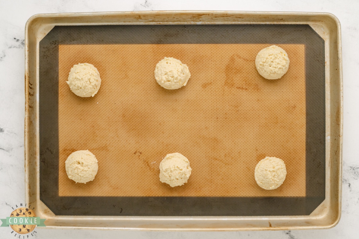 Scooped orange cookies on cookie sheet.