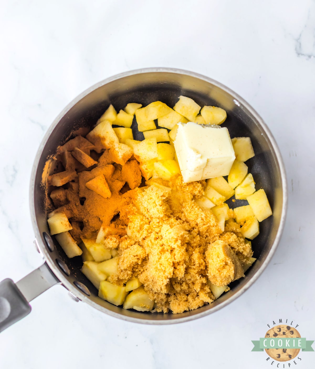 Apples with butter, cinnamon, and brown sugar in a saucepan. 