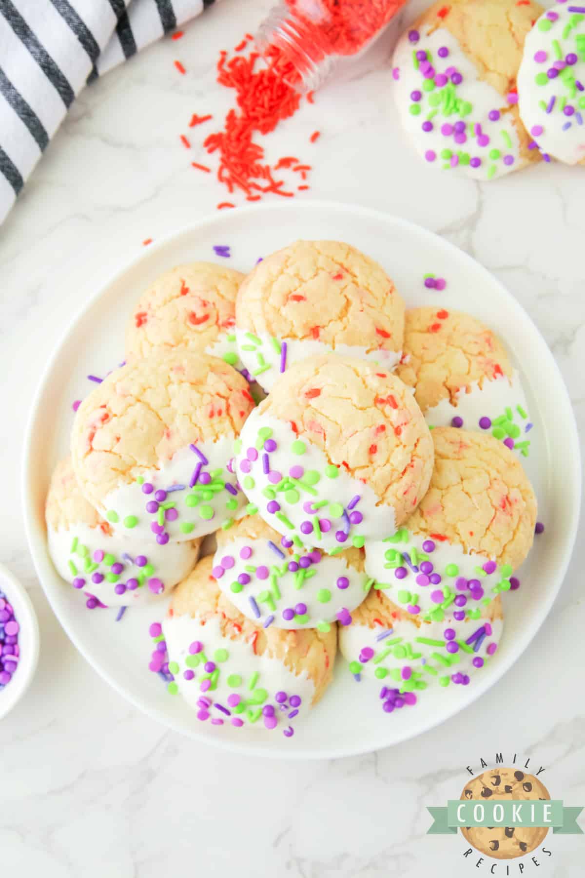 Halloween Cake Mix Sprinkle Cookies are easy to make and perfectly festive for Halloween. Use a cake mix, vanilla frosting, and colorful sprinkles to make these simple holiday cookies.