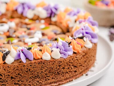 Halloween cookie cake with purple and orange rosette frosting and sprinkles