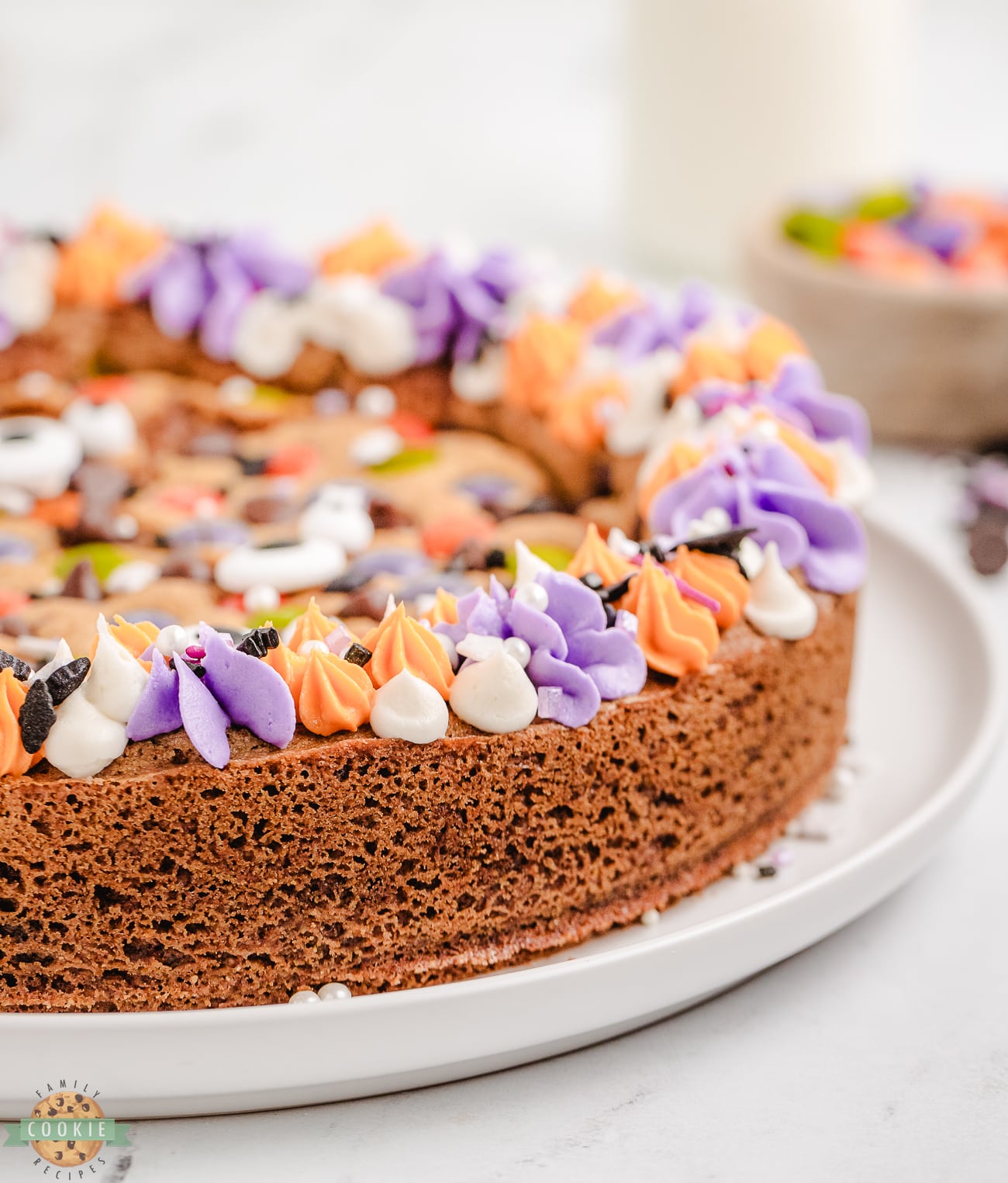 Halloween cookie cake with purple and orange rosette frosting and sprinkles