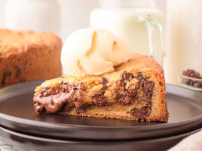 Nutella cookie cake topped with ice cream on a black plate