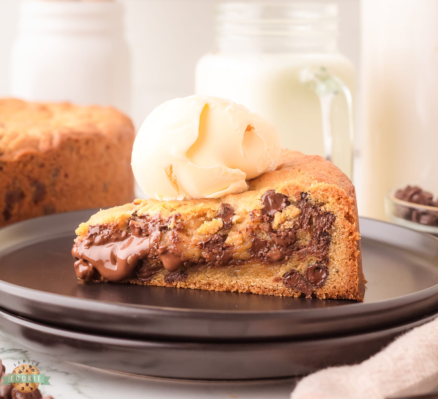 Nutella cookie cake topped with ice cream on a black plate